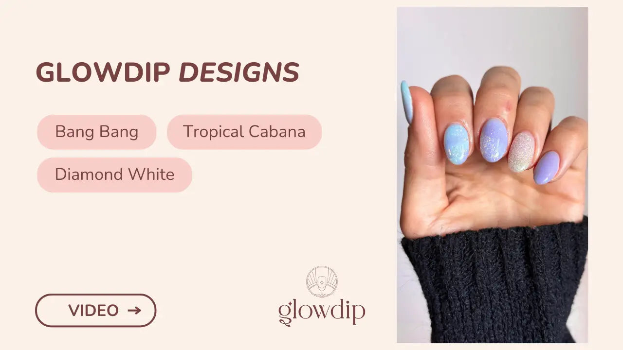 Een hand met lange lichtblauw en lavendel gekleurde nagels in een zachte verloop met glitterdetails bij oceaankus