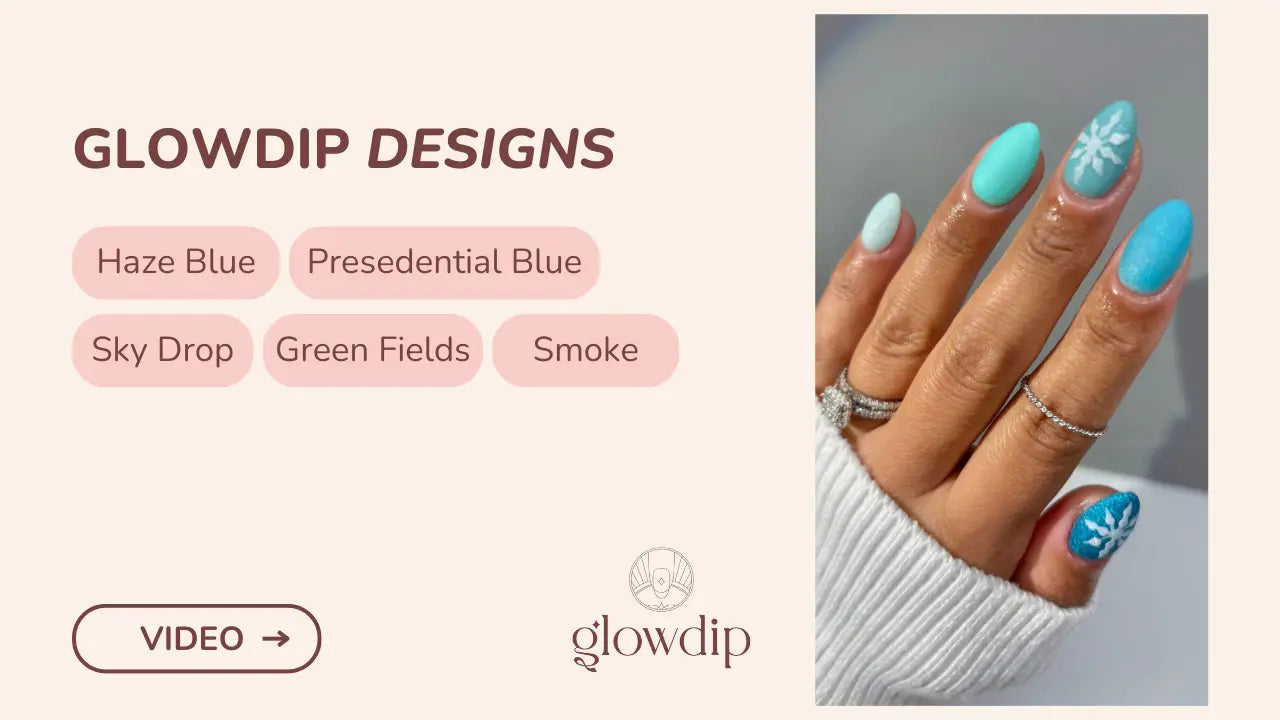 Een hand met lang, amandelvormige nagels in levendig turquoise met delicate witte sneeuwvlokdecors in een winterlandschap