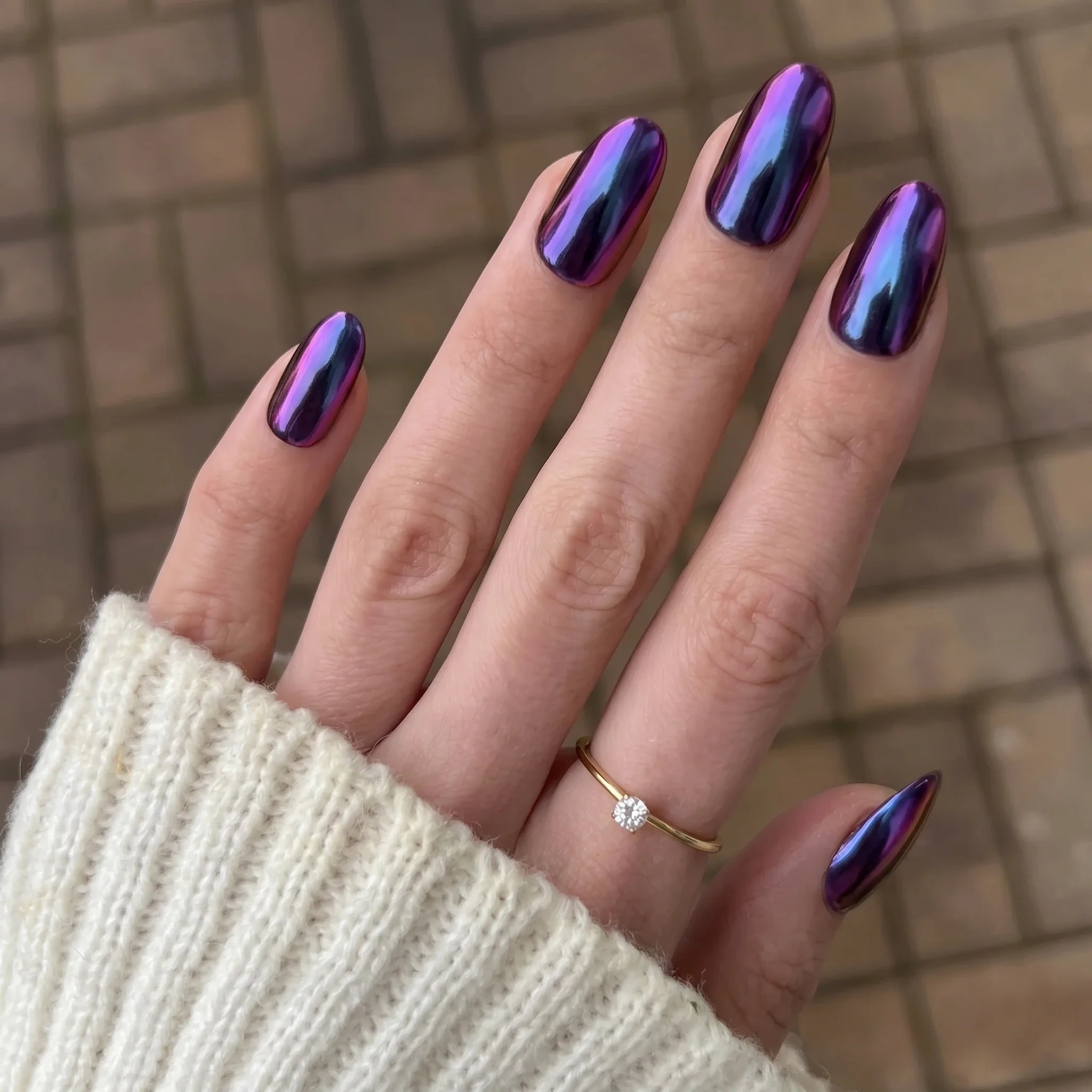 Shimmerende iriserende paarse en blauwe nagellak met een glanzende metalen finish van emerald shift chrome powder