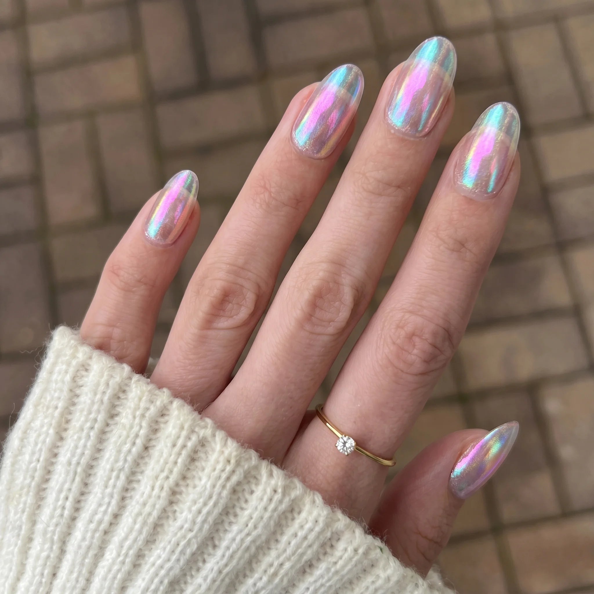 Iridescente holografische nagellak emerald shift chrome powder met glanzende afwerking op amandelvormige nagels