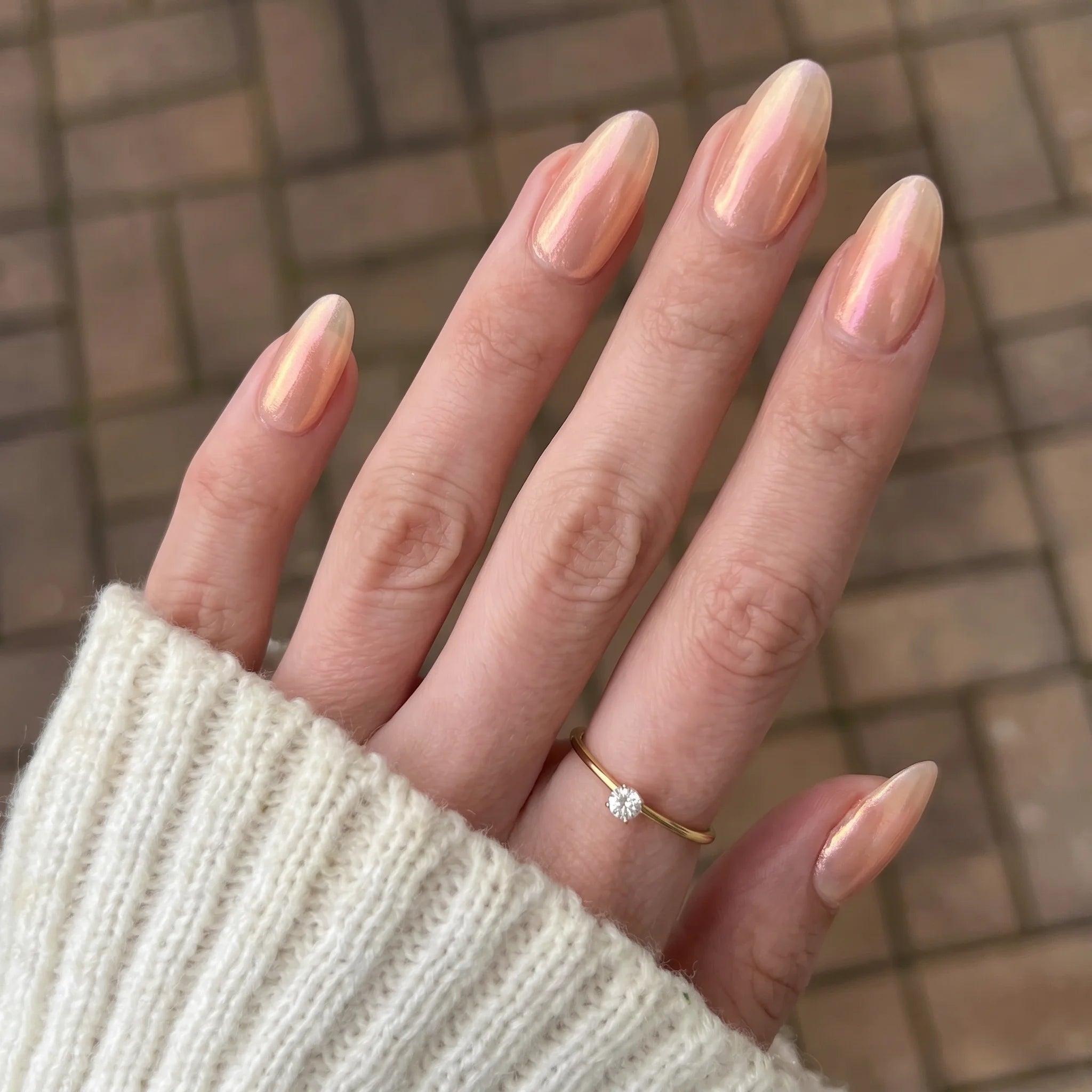 Een delicate gouden ring met een enkele fonkelende diamant in het centrum voor emerald shift chrome powder
